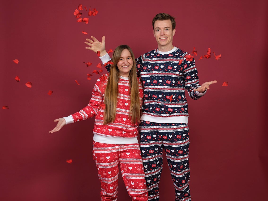 Una coppia in posa che indossa un pigiama con motivi a cuore.